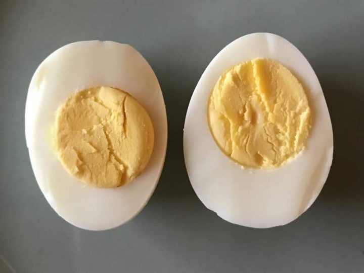 Sliced hard boiled egg on a blue plate.