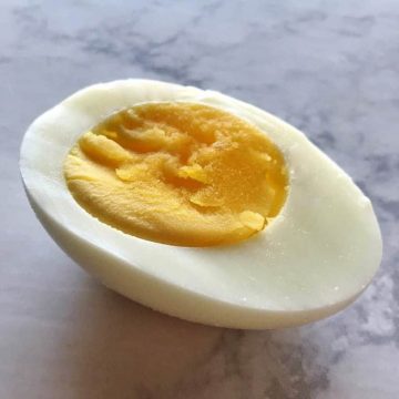Sliced hard boiled egg laying on the table.