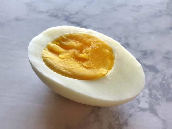 Sliced hard boiled egg laying on the table.