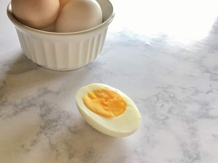 Sliced hard boiled egg laying on a table.