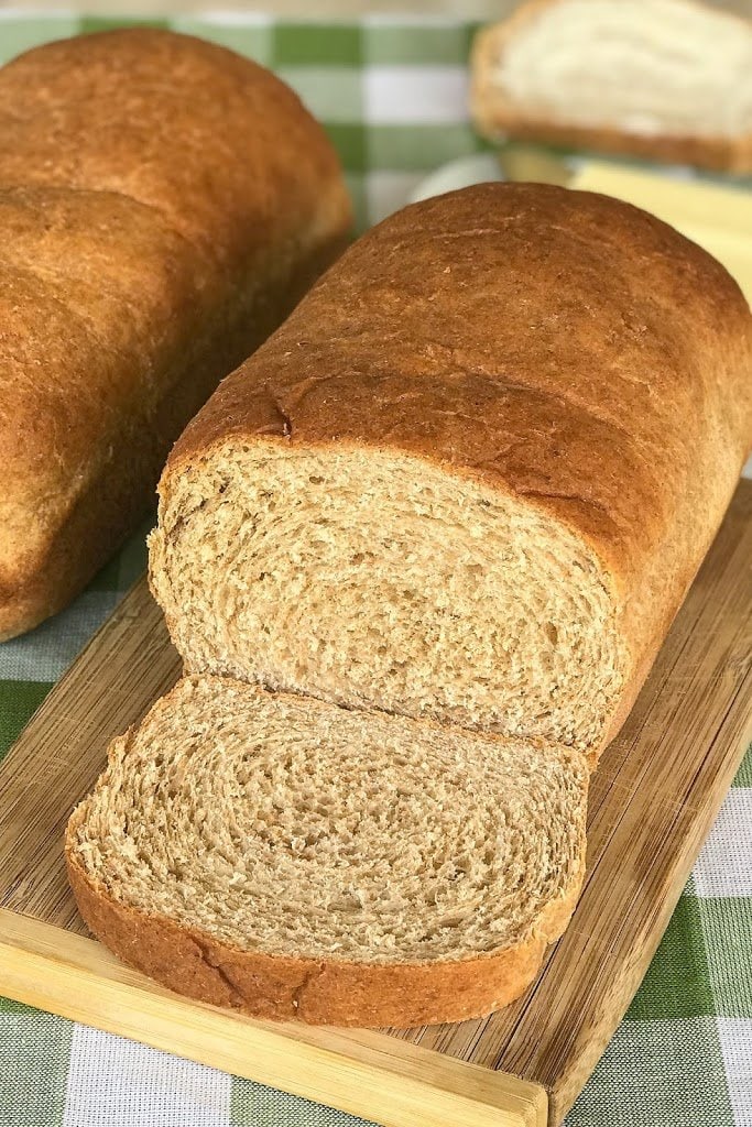 Honey Wheat Bread sliced on wooden cutting board.