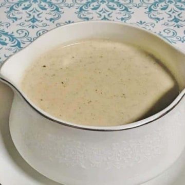 Creamy white country gravy in a white gravy bowl.