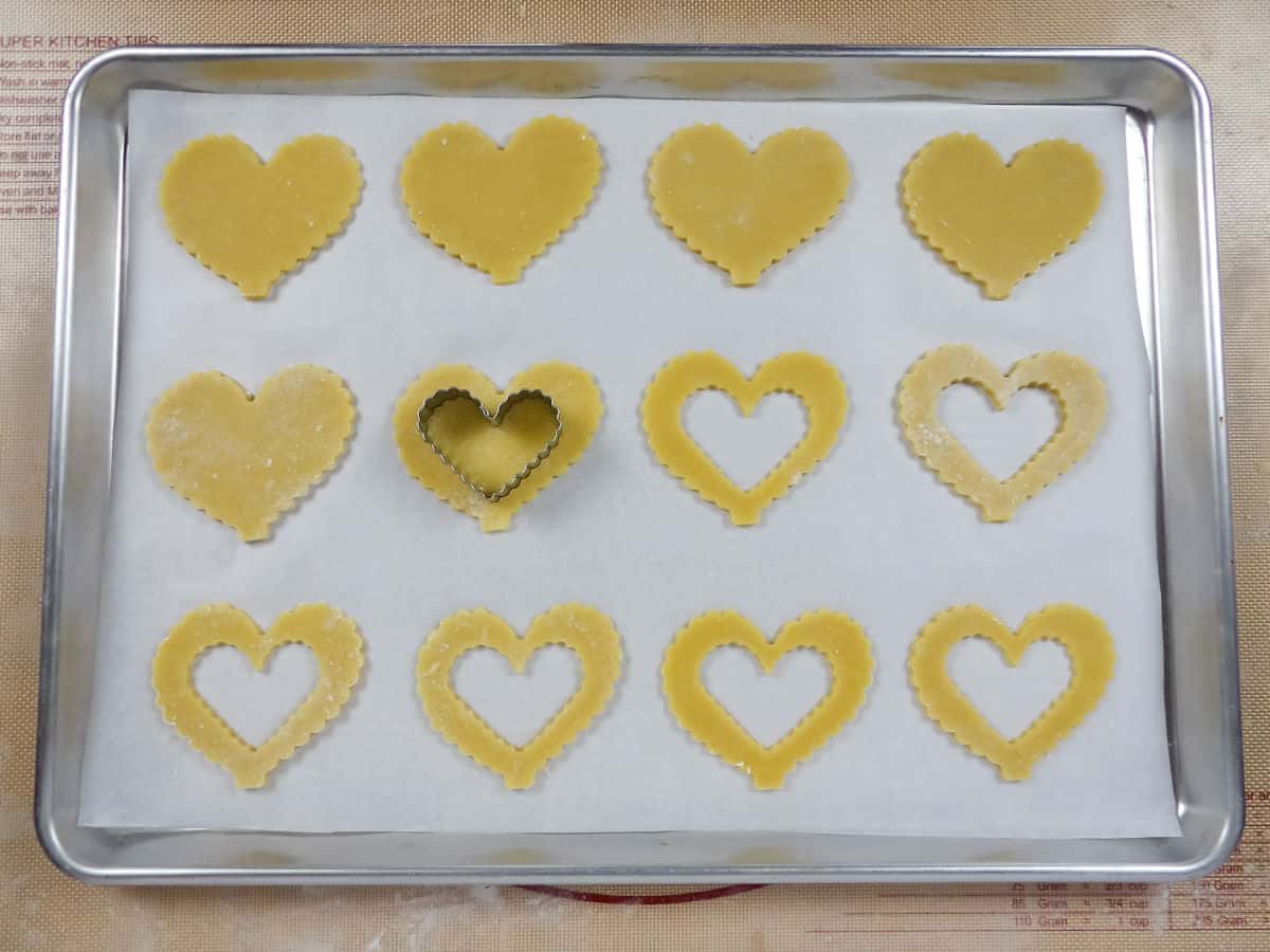 Cutting out small heart shaped "windows" in cookies.