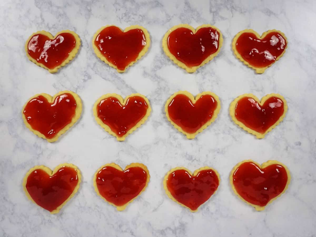 Heart Shaped Linzer Cookies coated with a layer of strawberry jam.