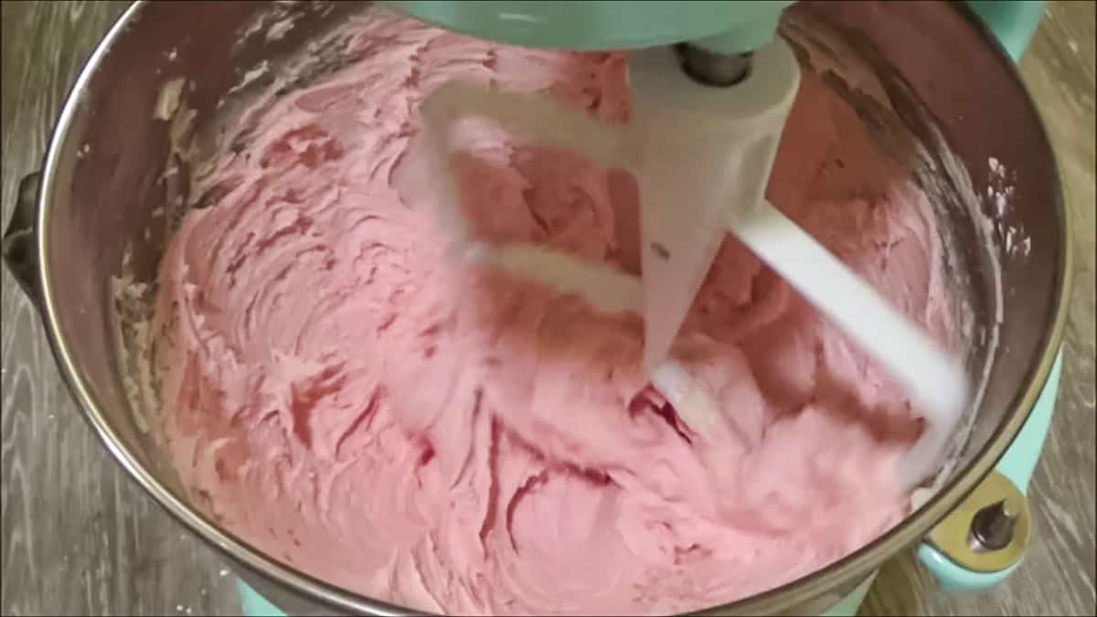 Mixing raspberry buttercream in a stand mixer.