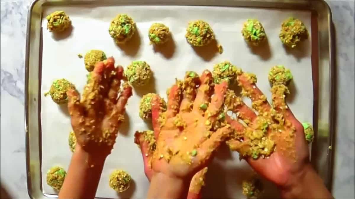 Showing messy hands from rolling oatmeal cookies dough into balls.