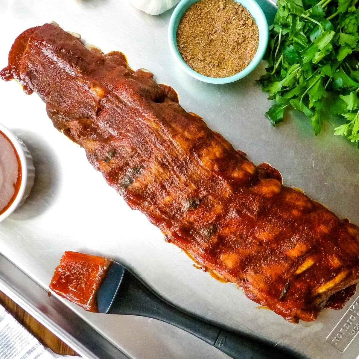 Baby back pork ribs that have been cooked in the Instant Pot laying on a baking sheet.