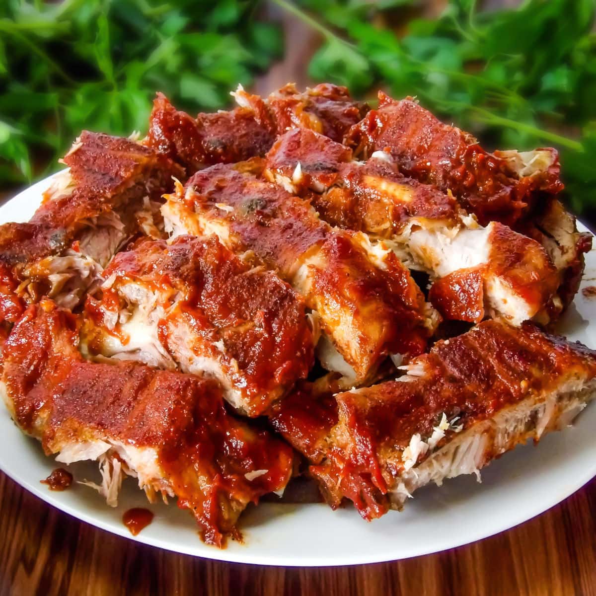 Sliced baby back ribs on a white plate that have been cooked in the pressure cooker.