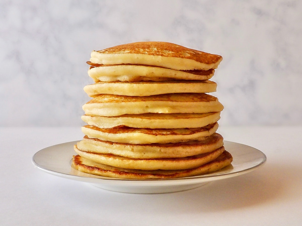 A stack of leftover mashed potato pancakes laying on a white plate.