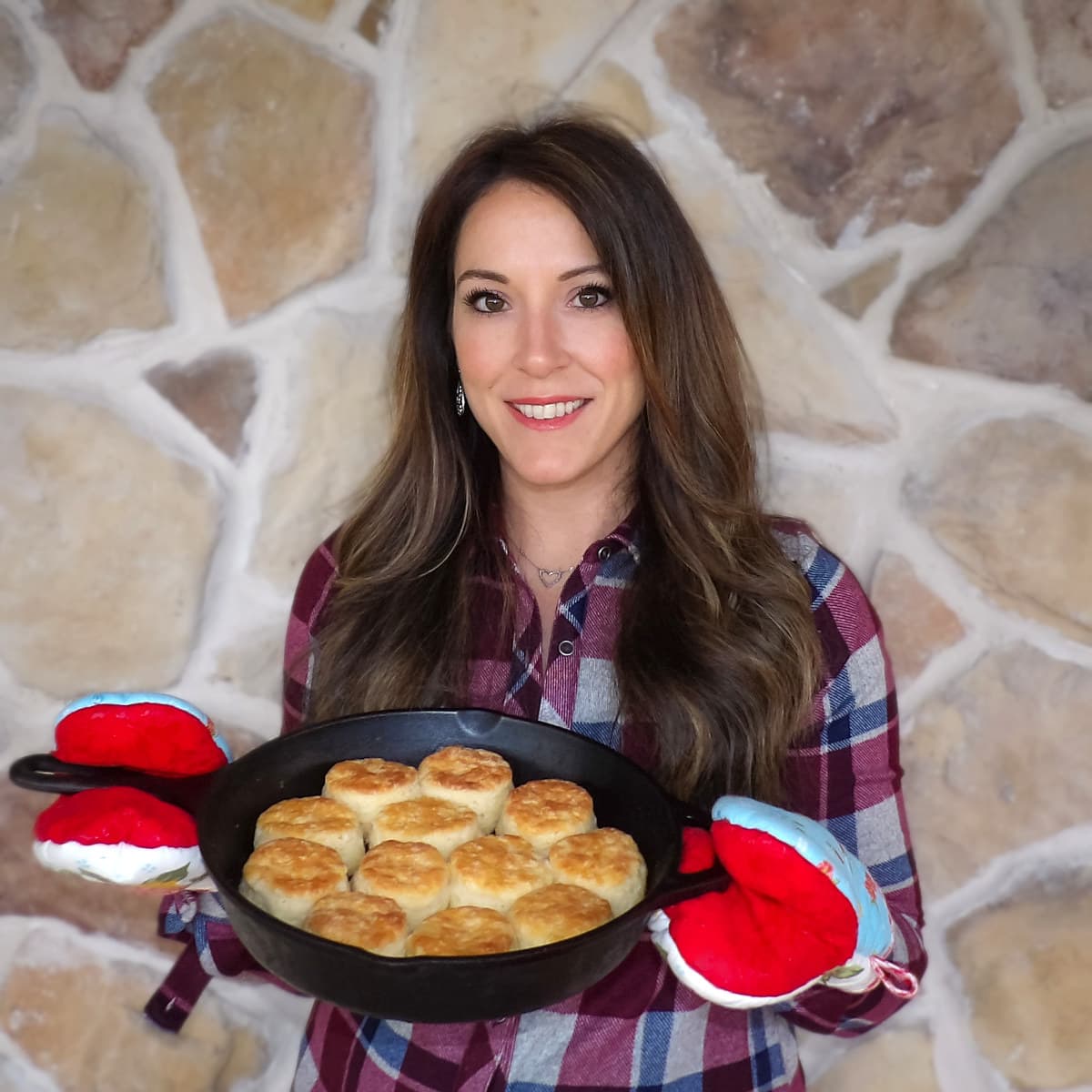 Christi, the owner of Ranch Style Kitchen, holding a cast-iron skillet full of homemade biscuits.