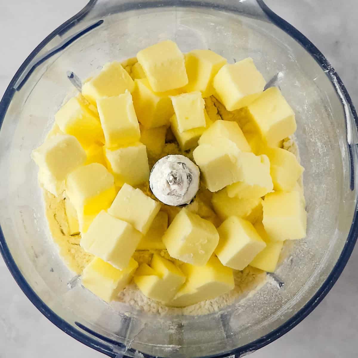 Self-rising flour and cubed butter in a food processor.