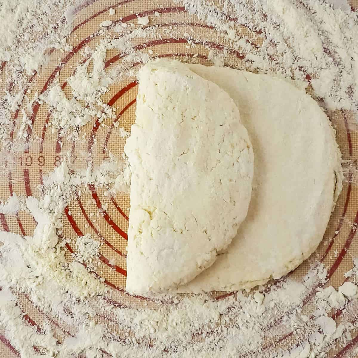 Buttermilk biscuit dough being tri-folded to create flaky layers.