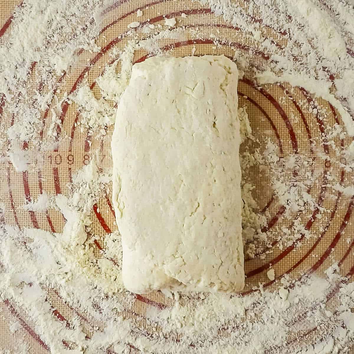 Buttermilk biscuit dough being tri-folded to create flaky layers.