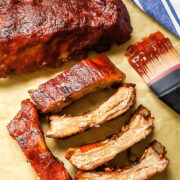 Sliced baby back ribs on a piece of parchment paper.
