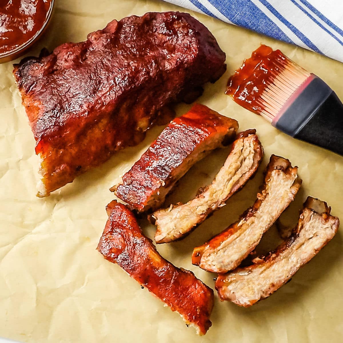 Sliced baby back ribs on a piece of parchment paper.