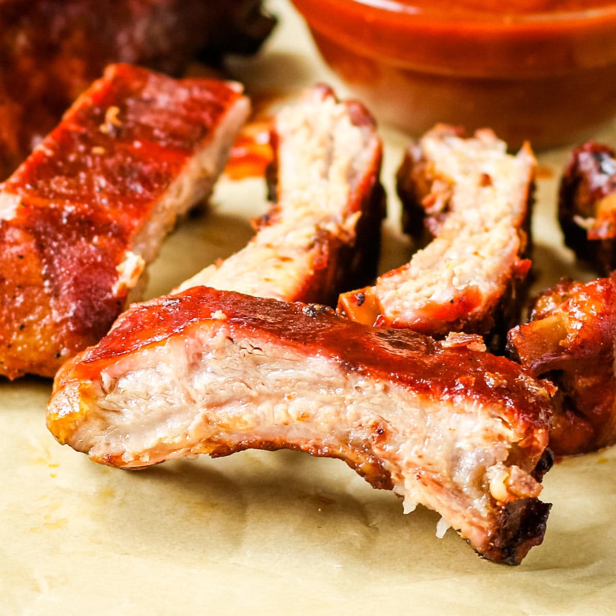 Sliced baby back ribs on a piece of parchment paper.