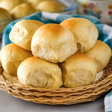 Stacked bread rolls on a white plate.