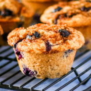 Homemade blueberry muffins on a black cooling rack.