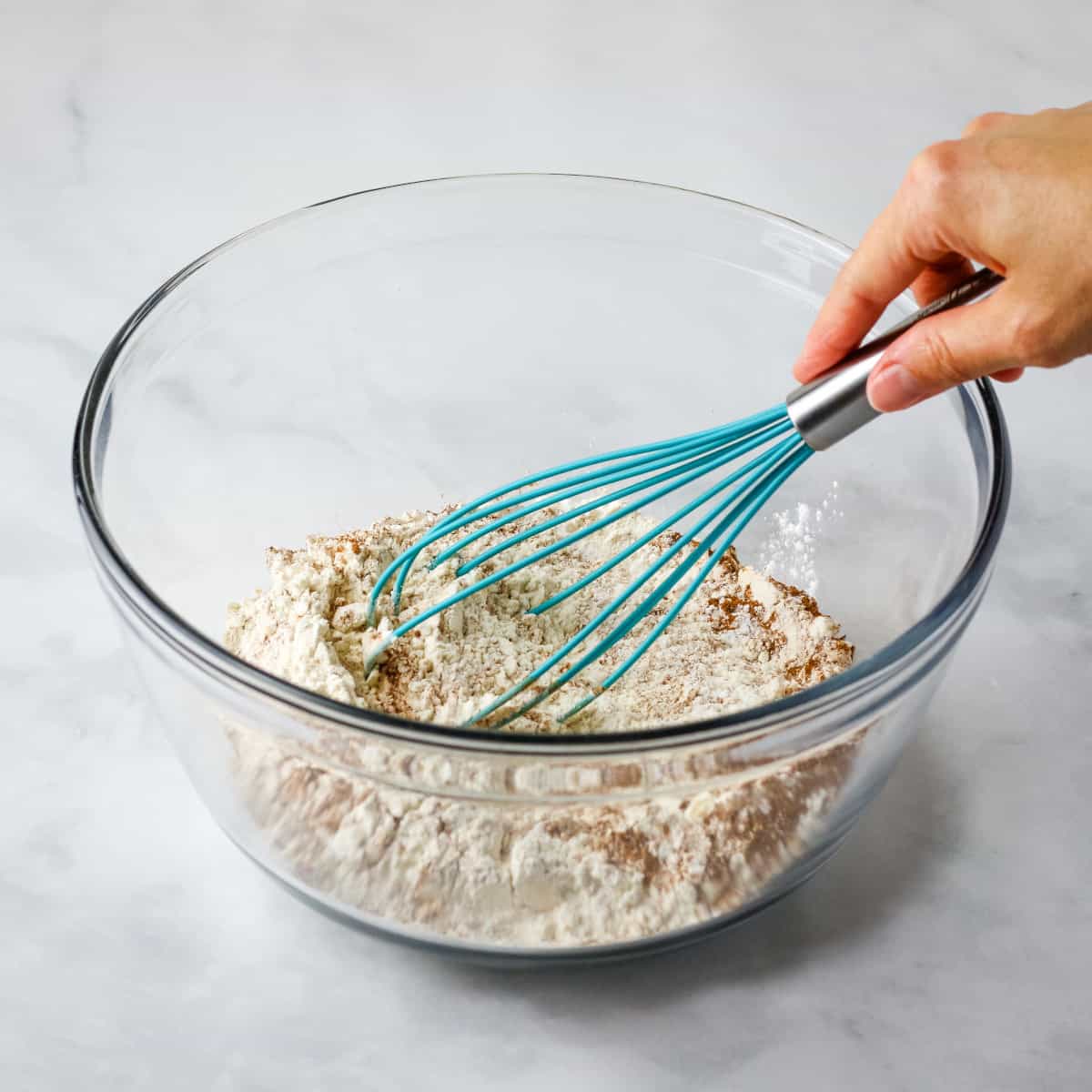 Whisking the dry ingredients together in a large glass bowl.
