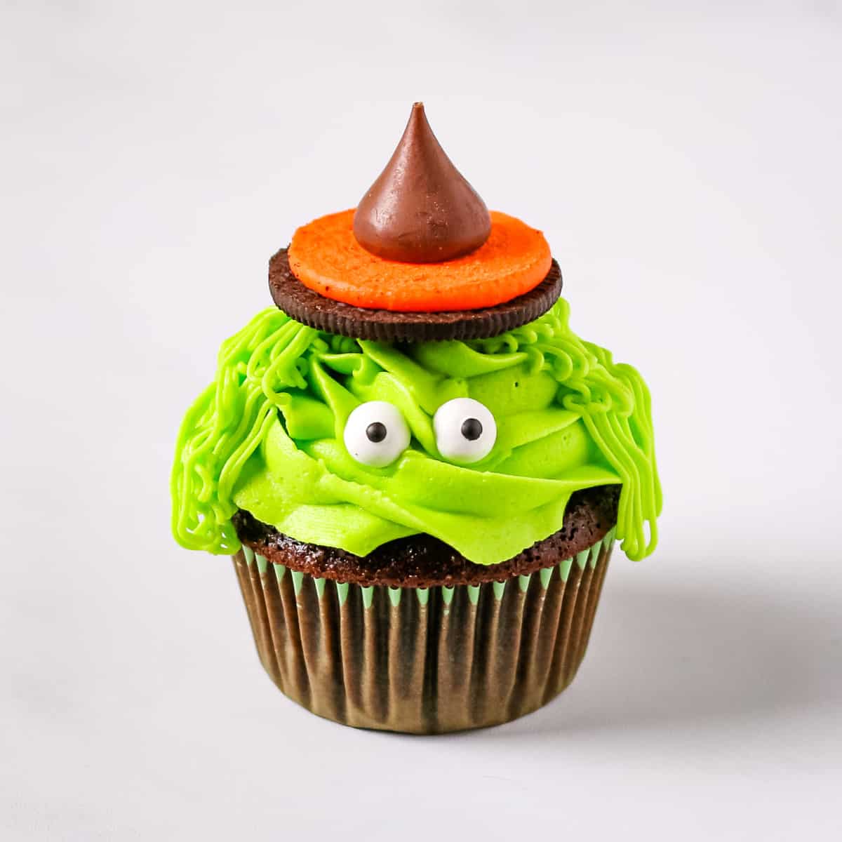 A chocolate cupcake decorated as a green Halloween witch.