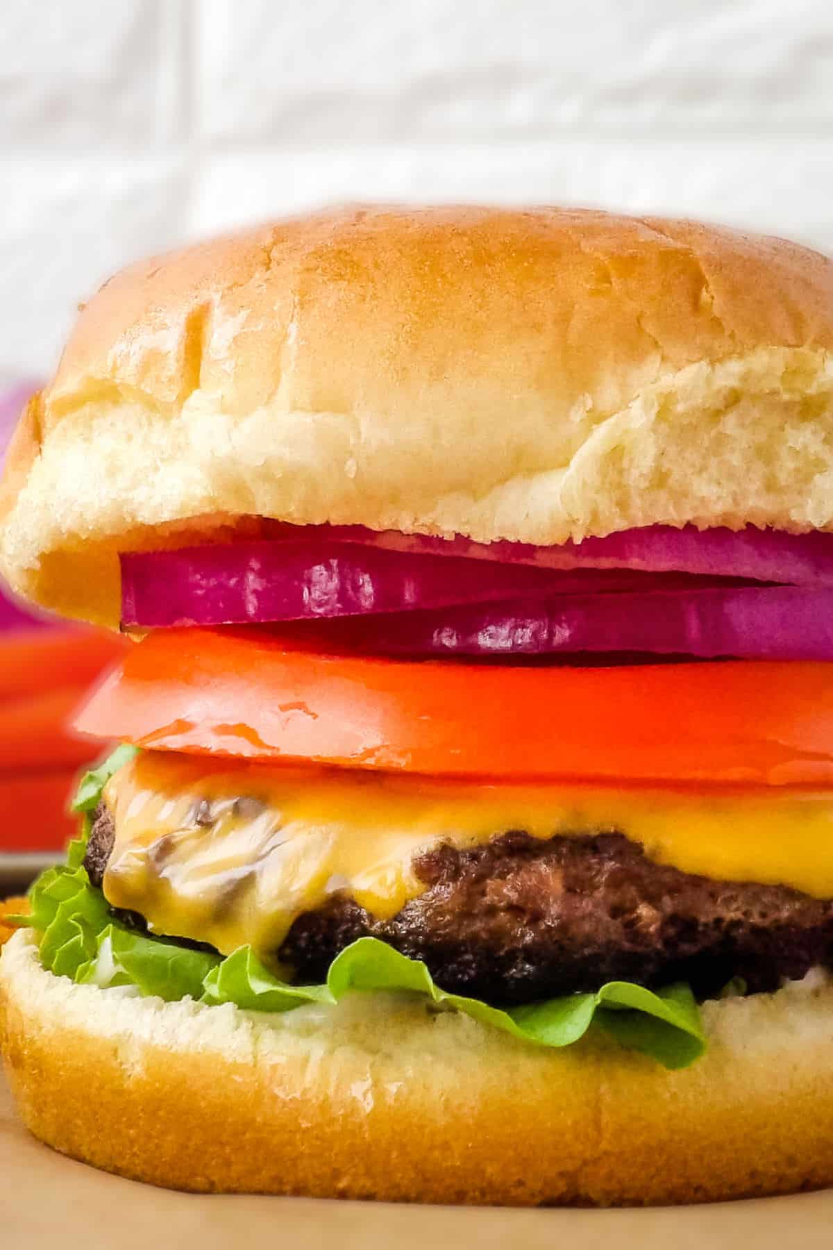 Grilled deer burger on a brown countertop.