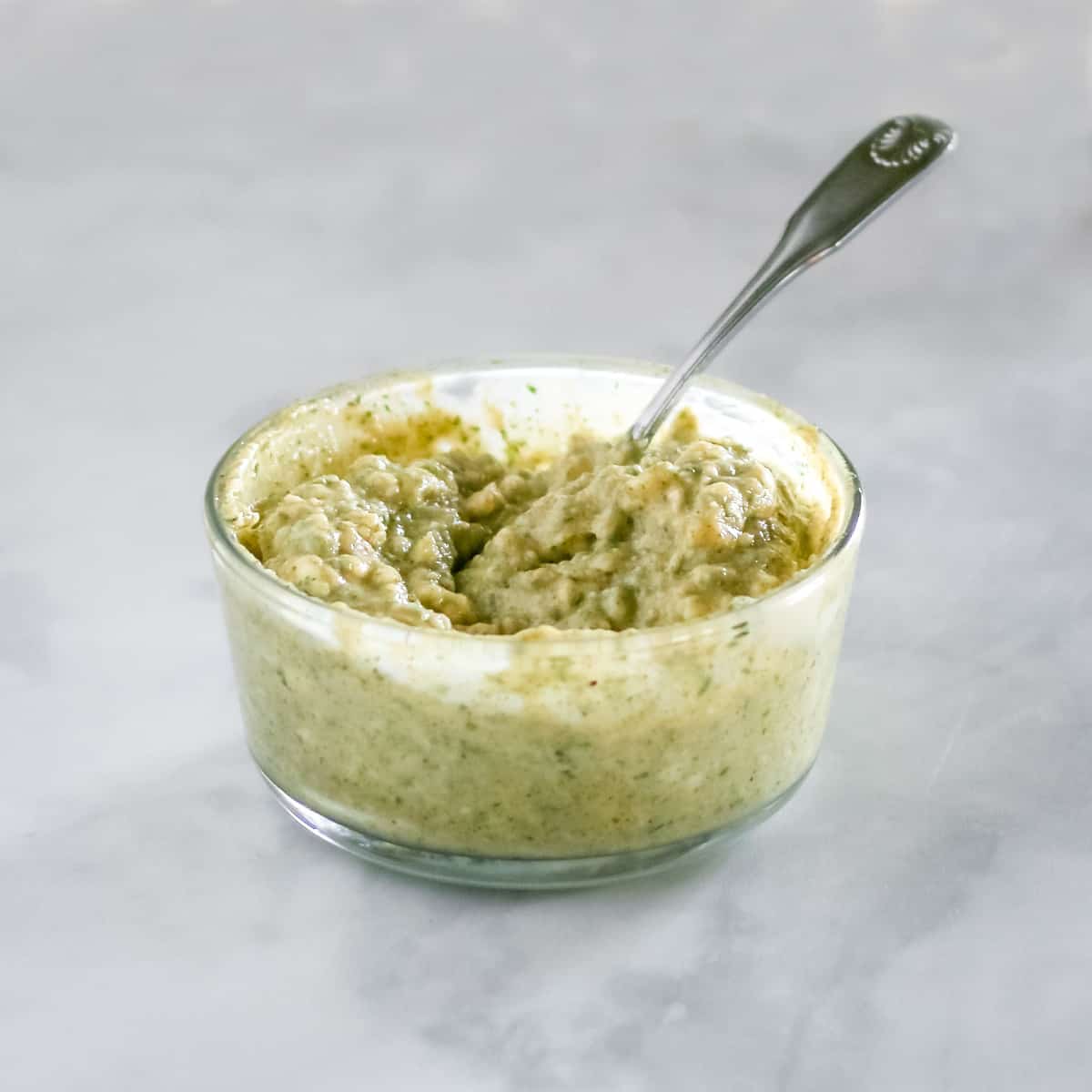 Garlic herb butter in a small glass bowl.