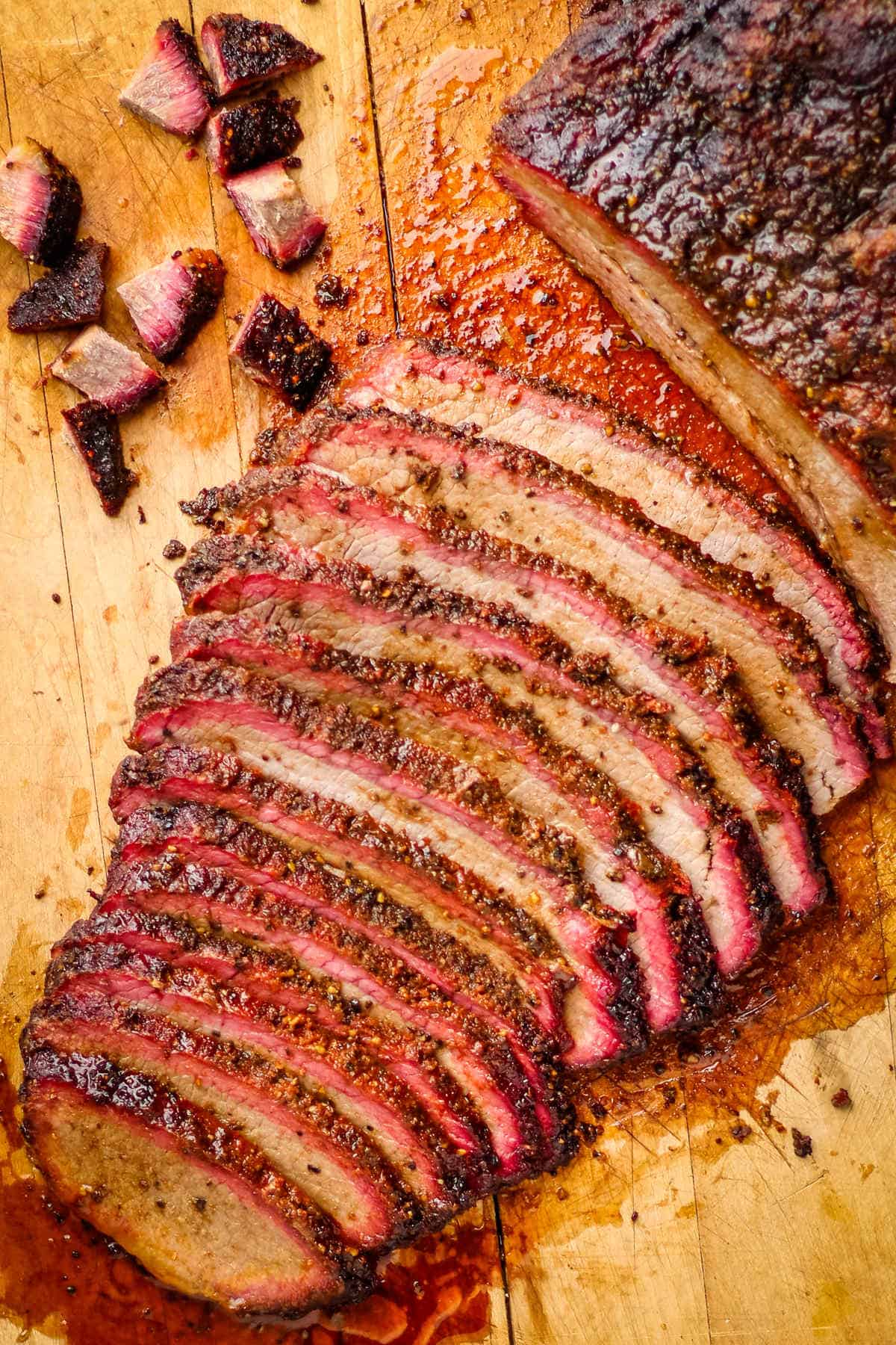 Sliced smoked pellet grill brisket on a wooden cutting board.