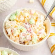 Ambrosia salad in a white bowl on a white table.