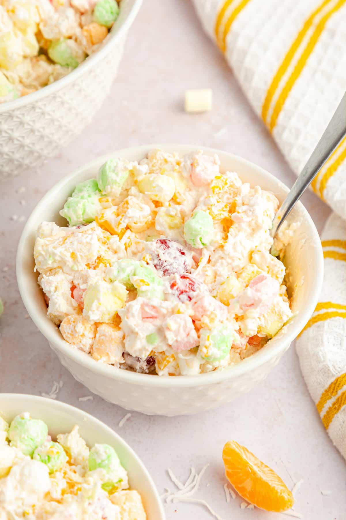 Ambrosia salad in a white bowl on a white table.