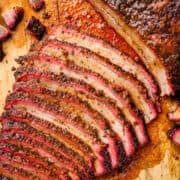 Sliced smoked brisket on a wooden cutting board.
