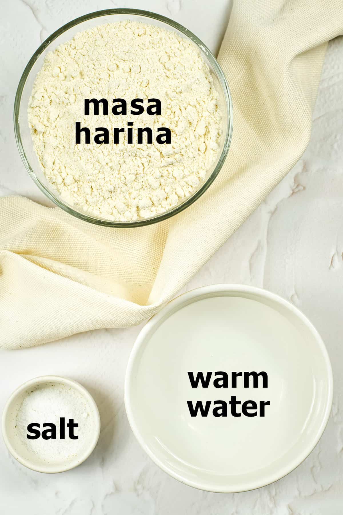 Ingredients for corn tortillas: masa harina, warm water, and salt.