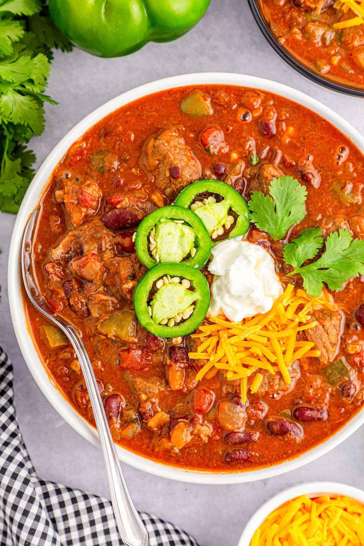 Chili con carne with beans in a white bowl with a silver spoon.