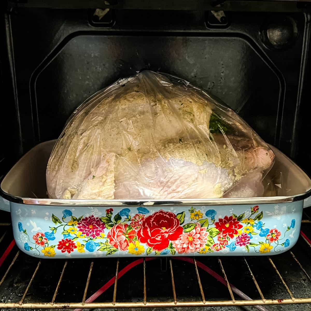 Baking a turkey in an oven bag in a blue floral roasting pan.